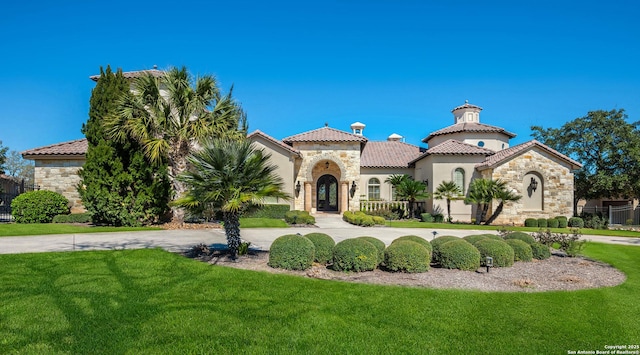 mediterranean / spanish-style home with a front lawn