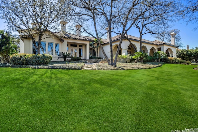 mediterranean / spanish home featuring a front yard