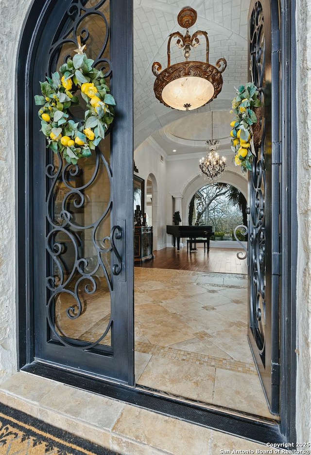 entryway with a chandelier and ornamental molding