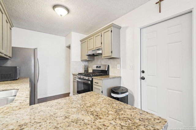 kitchen featuring gas range, tasteful backsplash, and a textured ceiling