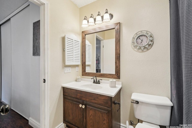 bathroom with hardwood / wood-style floors, vanity, and toilet