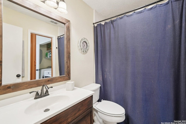 bathroom with a textured ceiling, vanity, and toilet