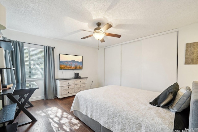 bedroom featuring ceiling fan, dark hardwood / wood-style flooring, a closet, and a textured ceiling