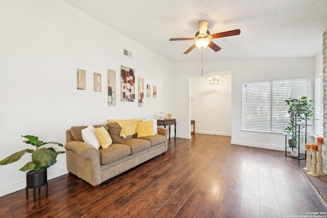 living room with dark wood-type flooring, a textured ceiling, and ceiling fan