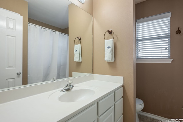 bathroom with tile patterned flooring, vanity, and toilet