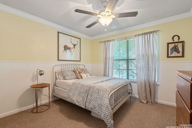 carpeted bedroom featuring ceiling fan and crown molding