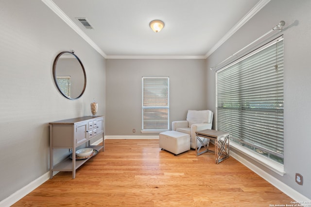 living area featuring light wood-type flooring and crown molding