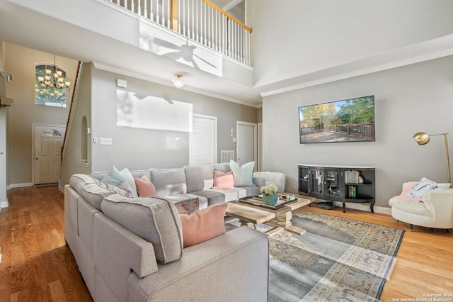 living room featuring a high ceiling, a chandelier, and wood-type flooring