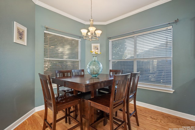 dining area featuring ornamental molding, a notable chandelier, and wood-type flooring