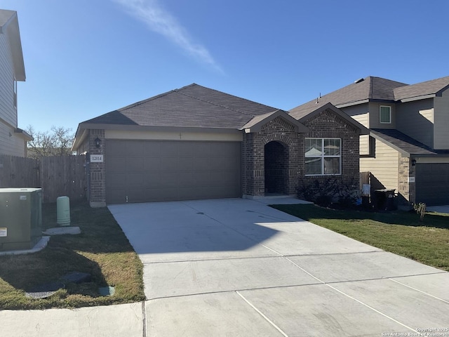 view of front of property featuring a front yard, a garage, and central AC