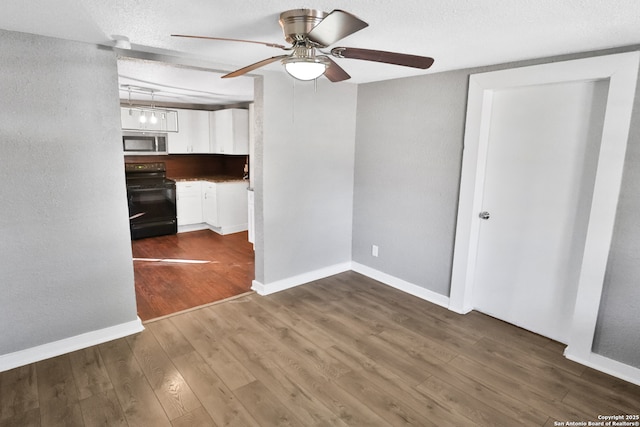 interior space with a textured ceiling, ceiling fan, and hardwood / wood-style floors