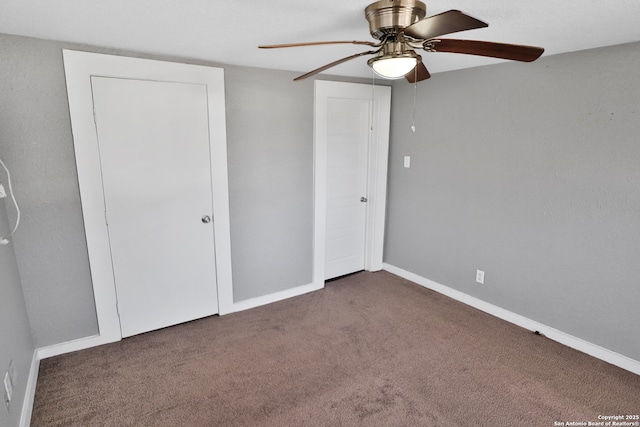 unfurnished bedroom with dark carpet and ceiling fan