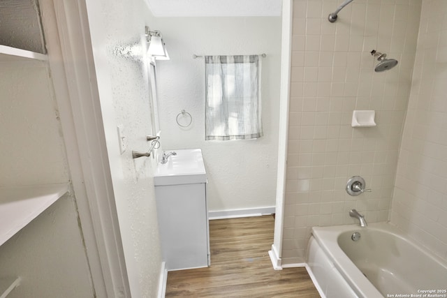 bathroom featuring vanity, hardwood / wood-style floors, and tiled shower / bath