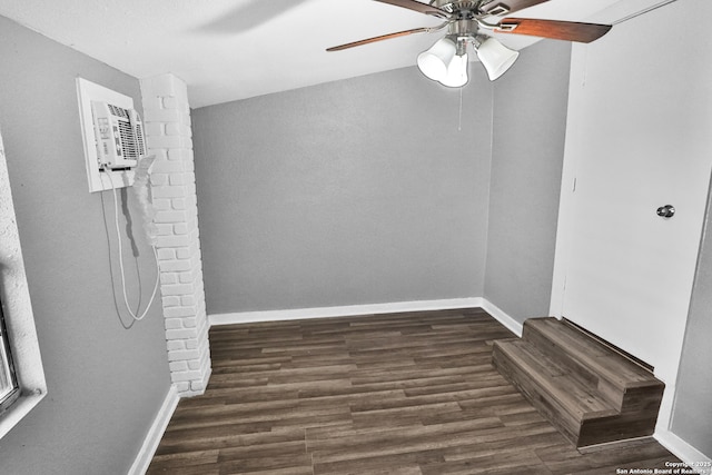 spare room with an AC wall unit, ceiling fan, and dark hardwood / wood-style flooring