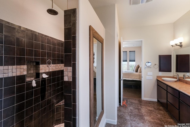 bathroom with a tile shower and vanity