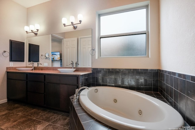 bathroom with a relaxing tiled tub, tile patterned flooring, and vanity