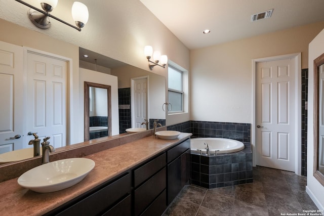 bathroom featuring vanity and a relaxing tiled tub