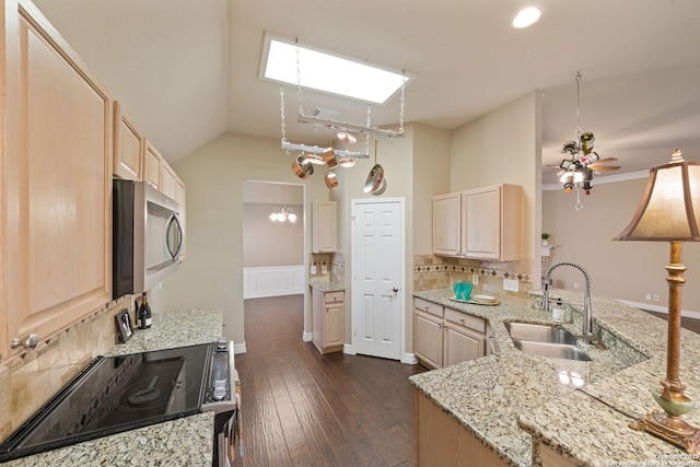 kitchen with light stone countertops, lofted ceiling, light brown cabinetry, sink, and ceiling fan