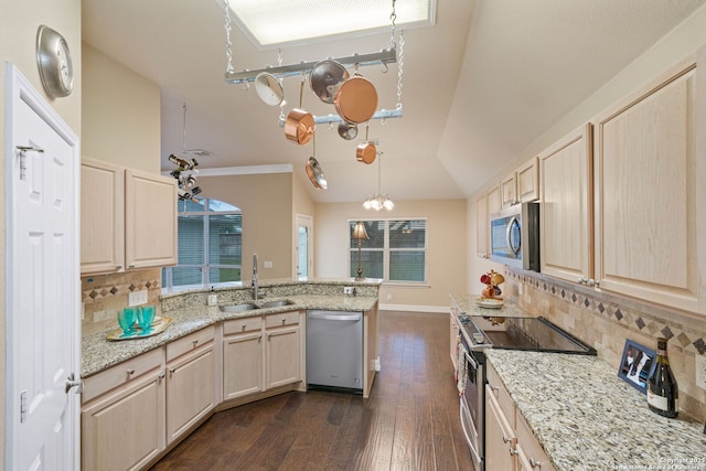 kitchen featuring stainless steel appliances, light brown cabinetry, backsplash, and sink