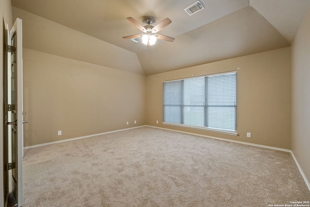 carpeted spare room featuring ceiling fan and vaulted ceiling