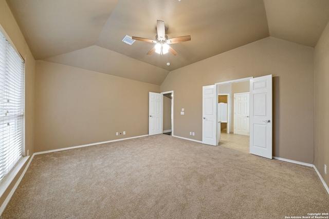 unfurnished bedroom with ceiling fan, vaulted ceiling, and light carpet