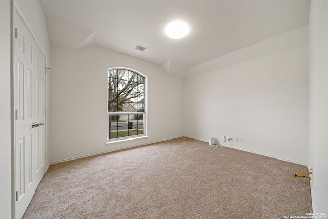 empty room with light carpet and vaulted ceiling