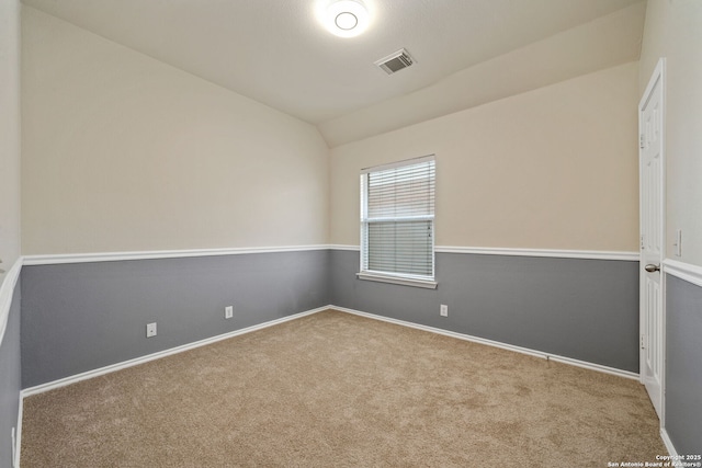 carpeted spare room featuring lofted ceiling