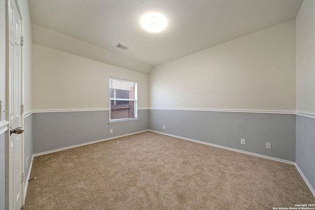 spare room with light carpet and lofted ceiling