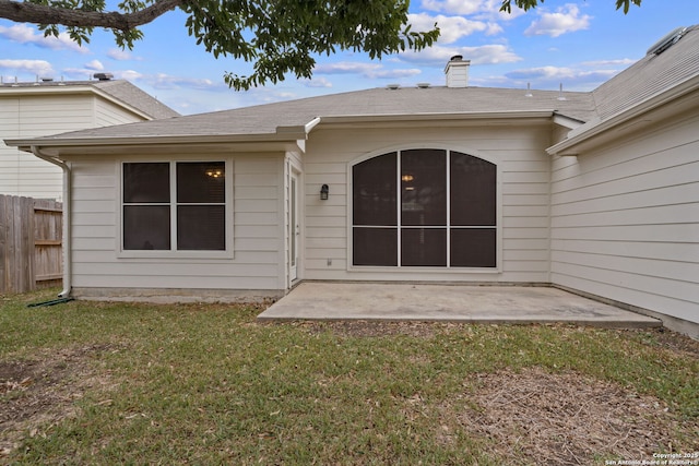 rear view of house with a lawn and a patio area