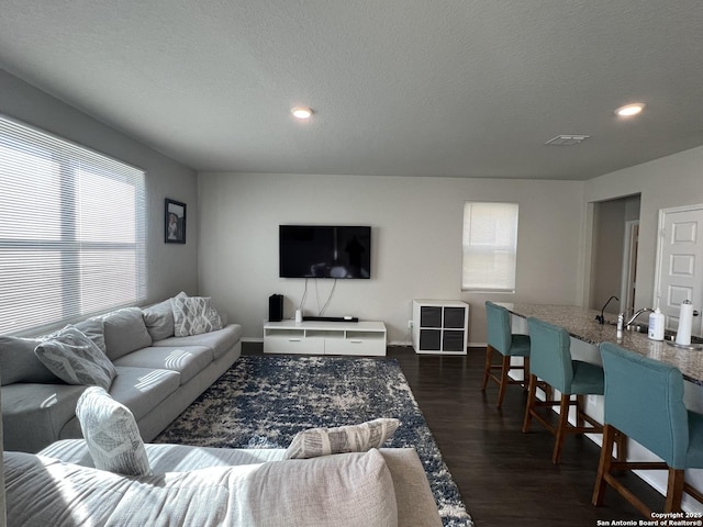 living room with dark hardwood / wood-style flooring and a textured ceiling