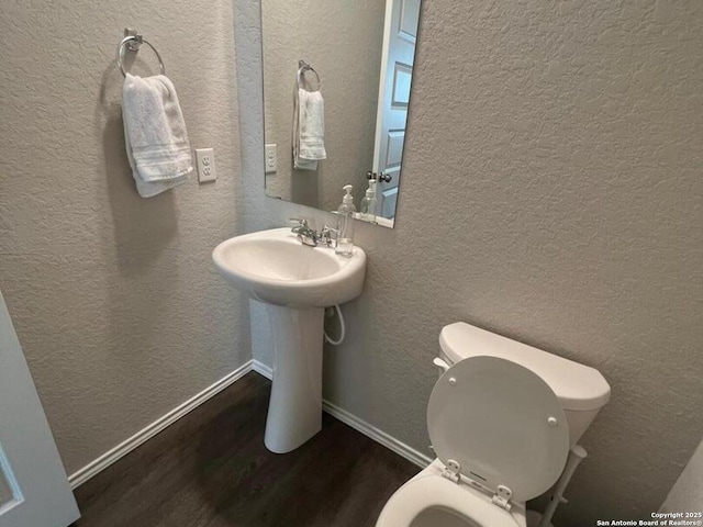 bathroom featuring hardwood / wood-style floors and toilet