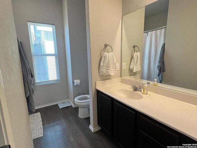 bathroom with vanity, toilet, plenty of natural light, and wood-type flooring