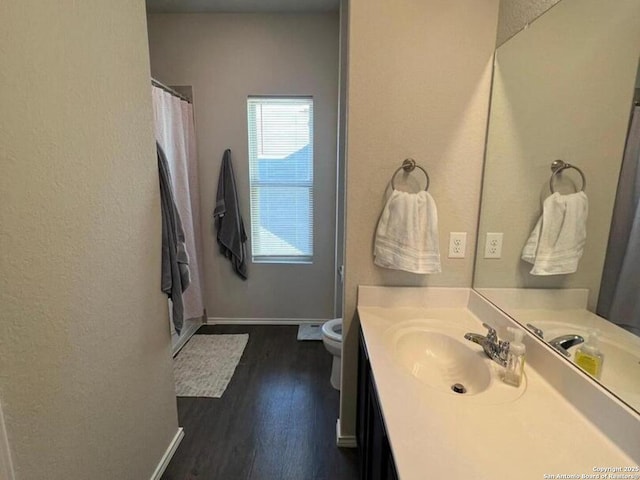 bathroom featuring toilet, wood-type flooring, and vanity