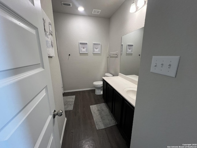 bathroom with toilet, wood-type flooring, and vanity