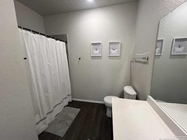 bathroom with toilet, walk in shower, vanity, and hardwood / wood-style floors