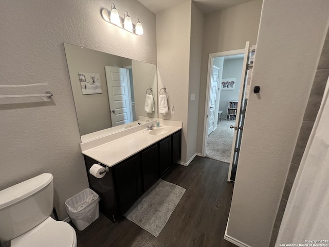 bathroom featuring toilet, wood-type flooring, and vanity