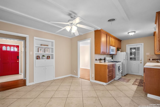 kitchen featuring white appliances, ceiling fan, decorative backsplash, light tile patterned flooring, and built in shelves