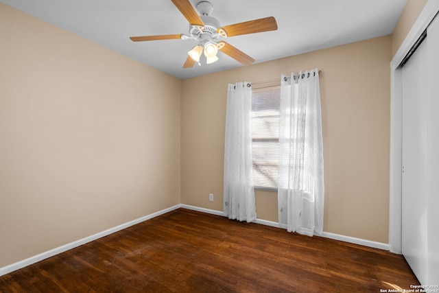 empty room featuring ceiling fan and dark wood-type flooring