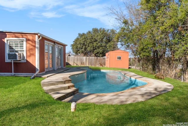 view of swimming pool with french doors, cooling unit, a yard, and a storage shed