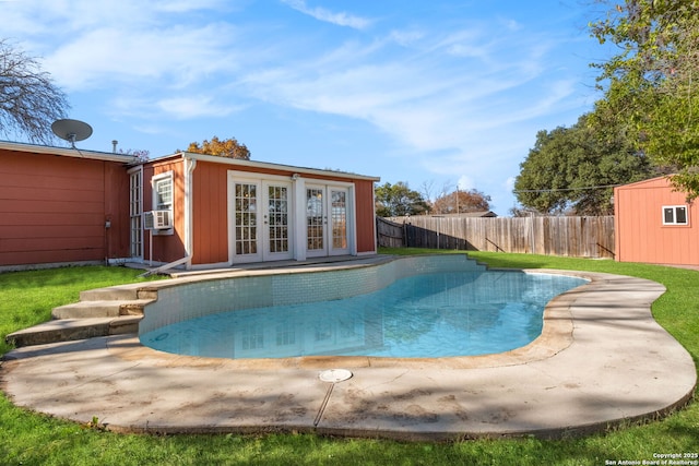 view of swimming pool with cooling unit and a storage shed