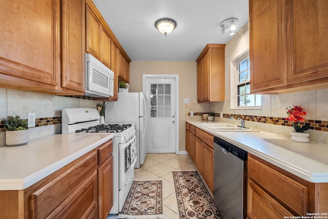 kitchen with white appliances, backsplash, light tile patterned flooring, and sink