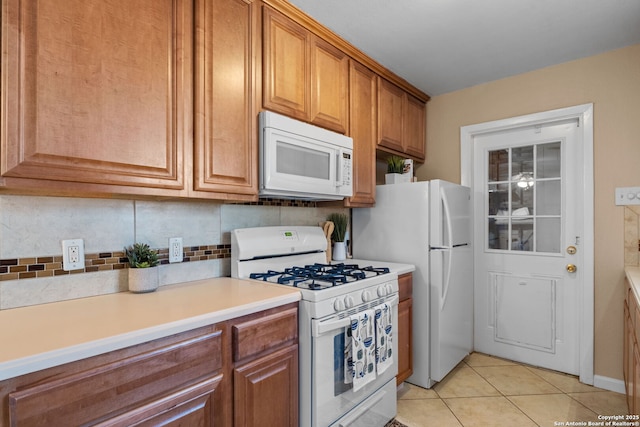 kitchen featuring white appliances, light tile patterned flooring, and backsplash