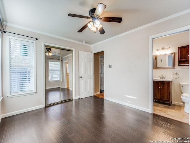 unfurnished bedroom featuring connected bathroom, a closet, ceiling fan, ornamental molding, and sink