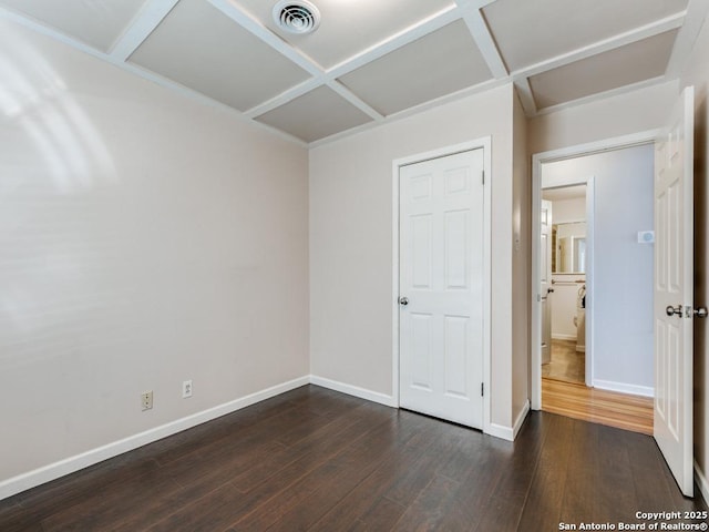 unfurnished bedroom with coffered ceiling and dark hardwood / wood-style floors