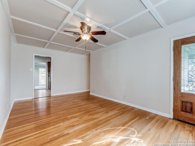 empty room with ceiling fan, light hardwood / wood-style floors, and coffered ceiling