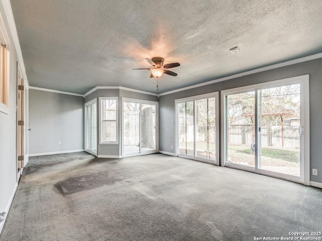 carpeted empty room with a textured ceiling, ceiling fan, and ornamental molding