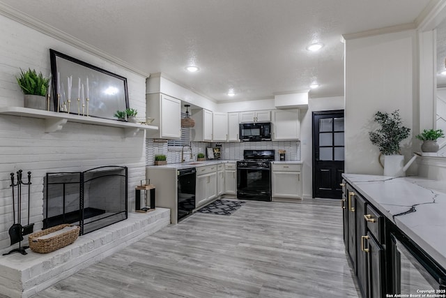 kitchen featuring white cabinets, black appliances, a fireplace, open shelves, and a sink