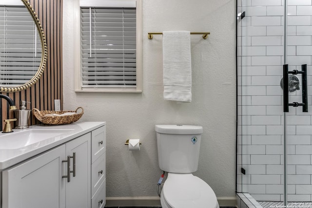 full bathroom with a textured wall, a stall shower, vanity, and toilet