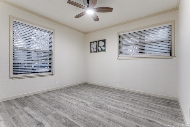 spare room featuring ceiling fan, baseboards, crown molding, and wood finished floors