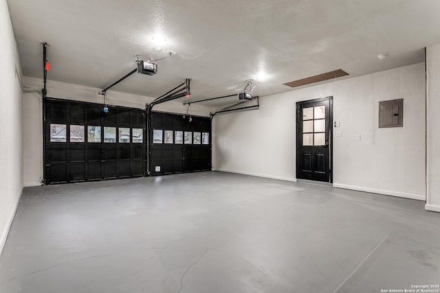 garage featuring a garage door opener, electric panel, and baseboards